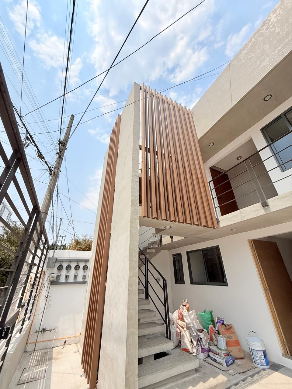 Escalera de concreto con peldaños volados junto a la celosía