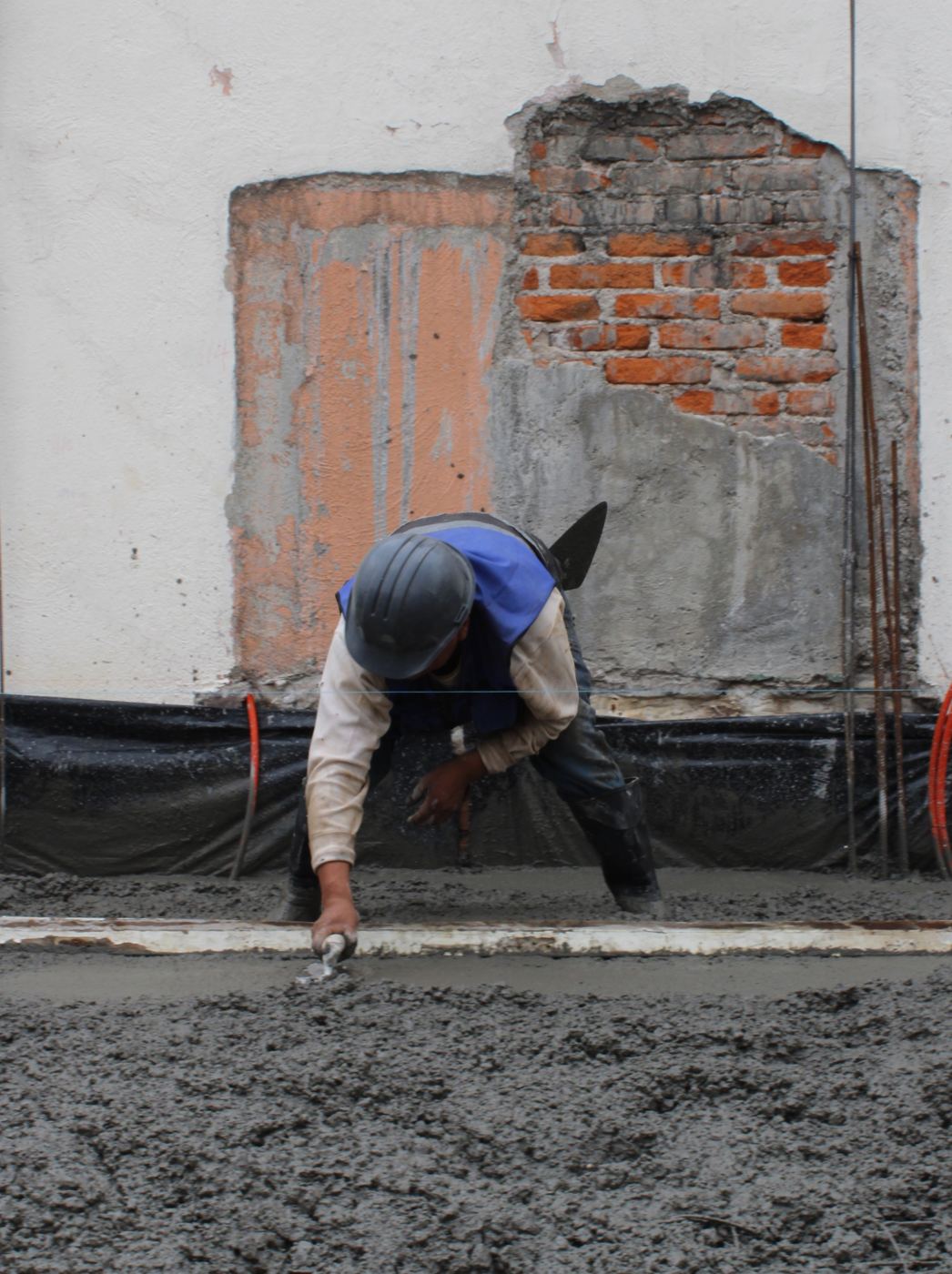 Trabajador nivelando el colado de una losa